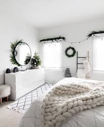 An elegant farmhouse christmas bedroom with a snowy tree with lights and ornaments, faux fur, a greenery wreath and silver ornaments an evergreen wreath with pinecones, evergreen garlands with bulbs and plaid bedding for a farmhouse christmas look Seasonal Holiday Archives Homey Oh My