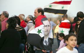 A syrian soldier, who has defected to join the free syrian army, holds up his rifle and waves a syrian independence flag in saqba, in damascus suburbs file photo: Pro Assad Syrians Show Support For At Independence Day Rally The Seattle Times