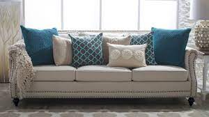 5 Ways To Decorate A Neutral Sofa With Throw Pillows Hayneedle Beige Sofa Living Room Cushions On Sofa Teal Pillows