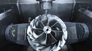 5축 가공기가 알루미늄 블록을 요리조리 돌려가며 복잡한 곡면의 터빈 블레이드를 깎아내는 정밀 가공 장면