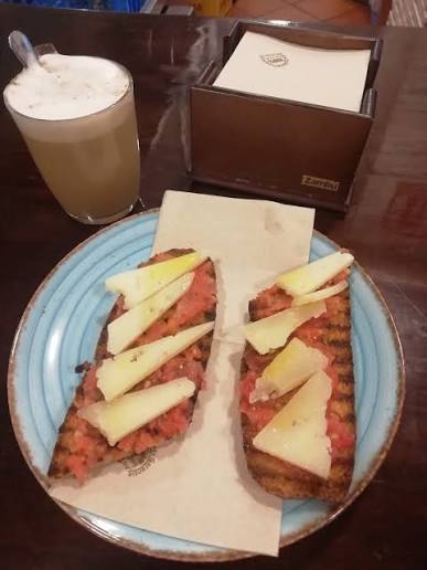 Tostada de pan integral con tomate .queso manchego curado .acompañado de cafe con leche de avena😋😋