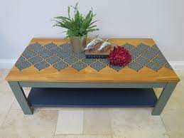 Continue that theme with the coffee table by layering a grey stone vase on top of a marble top, but fill it with a riotous mixed bouquet of blooms in various shades of pink. Stencilled Coffee Table Coffee Table Upcycle Coffee Table Top Ideas Painted Coffee Tables