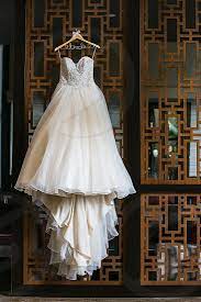 Two wedding dress with a mirrored jewelry box on wooden boards with a bouquet of. Hanging Wedding Dress By Lin And Jirsa Photography Photo Stock Snapwire