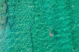 Seul Un Homme Nudiste Nu Plonge Dans Des Palmes, Un Masque De Plongée En  Apnée Et Un Tube Nageant Dans La Mer, L'eau Turquoise De L'océan. Vue De  Dessus. Vue Aérienne, Drone,