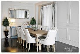 Contemporary dining room features a dark gray velvet tufted dining settee with restoration hardware aero white marble and brass oval dining table, dark surrounded by restoration hardware bondi teak lounge chairs, a black aluminum dining table is positioned on gray pavers under skylights lit by. Classy Glam Living
