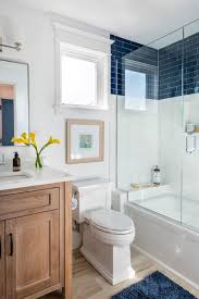 White paint, white beadboard wainscoting, and a vintage white tub come to life in this simple bathroom, accented with a natural wood floor and a pop of blue from the window planters. 9 Cool Blue Bathroom Ideas Town Country Living