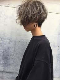 kurzhaarfrisuren frauen frech blonde strahne schwarzer sweatshirt ohrringe grauer hintergrund haarschnitt kurz haarschnitt frisuren