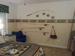 Another spot where we have highlighted some of the vintage fishing paraphernalia is in my husband's trophy room. Fishing Theme Boys Bedroom Want To Do The Top Fishing Rod Picture Frames Fishing Bedroom Fishing Themed Bedroom Boys Room Decor