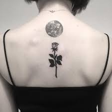 Here is a double exposure tattoo of moon that is perfectly placed on the back of the neck of this woman. Black Rose And Full Moon Tattoo On The Back Tattoogrid Net