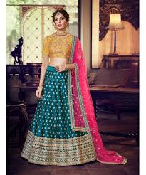 One of the best combos to put and something that has a whole bunch of variations, the blue and pink combination half saree is to die for and is totally trending this season. Peacock Blue Colour Satin Silk Lehenga With Mustard Colour Handloom Silk Choli And Pink Colour Net Dupatta Nakkashi 3226654