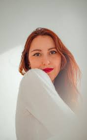 Woman in red shirt holding pink rose photo