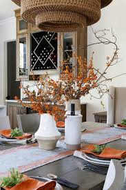 Part of the dining room. Stoneware Vases Filled With Decorative Branches Sit Atop A Wood Dining Table Hgtv