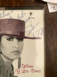 This image is a framed memorabilia piece featuring photos and information  about the iconic Tejano singer Selena. Selena Quintanilla