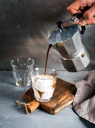 a glass of coffee with ice cream on a rustic wooden board drink is poured from a steel italian moka artisan cafe amazing food photography fresh roasted coffee