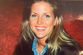 a woman with long blonde hair is smiling for the camera