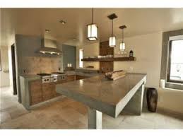 Cocina con gabinetes interiores en mdf, con puertas y vistas color salmon ( laqueado ) con jaladeras de barra y cubierta de formaica color madera con tono a escoger, gabinetes superiores con marco de aluminio y vidrio esmerilado, pollo de concreto de 18 cms., locker dispensero, para guardar la despensa ( de usos multiples )gabinetes inferiores de 72 cm de altura. Disenos Cocinas Revestidas Cemento Pulido 5 Como Organizar La Casa