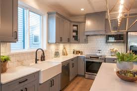 #light grey ( looks white really)stunning transitional kitchen features a stainless steel range sat against white herringbone backsplash tiles holding a light gray paneled hood flanked by light gray shaker cabinets fitted with polished nickel pulls and framed by ivory shiplap walls. Are Grey Kitchen Cabinets Better Than White Warline Painting Ltd