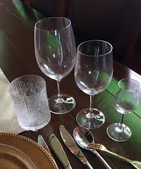 Holding the wine glass up against a white background, such as a napkin or table cloth, to evaluate its color and clarity. Placing Wine Glasses On Your Table
