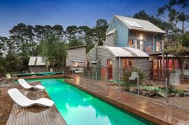 Love the blue beach side seats with those blue umbrellas. Energy Efficient Beach Style Retreat With Modern Cottage Design