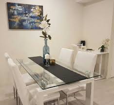 Get up to $100 in rewards! Adding A Black Table Runner Tall Blue Vase With Flowers Complimented With Glass And Gold Candle Black Glass Dining Table Glass Dining Table Decor Dining Table