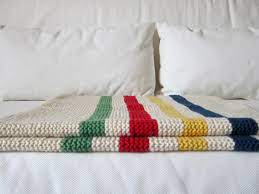 The pillow with colorful stripes is made with bravo big and is a perfect match to the blanket. New Store Sample Hudson Bay Inspired Crib Blanket Free Pattern Espace Tricot Blog