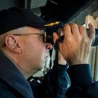 Boatswain's Mate Seaman Anthony Fabiochi, from Long Island, N.Y., scans the  sea for potential contacts while standing aft lookout watch aboard the  guided-missile destroyer USS Carney (DDG 64).