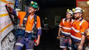 Group of diverse professionals in a modern office setting, discussing mining plans.
