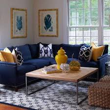 Polished nickel pendant chandelier over lack round pedestal table surrounded by blue dining chairs with silver nailhead trim. Yellow And Navy Living Rooms Design Ideas