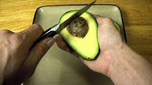 Use a knife to make a lengthwise cut around the seed, cutting through the skin and fruit. How To Tell When Ripe And Cut Open An Avocado Demonstration Of Cutting And Remove Pit Youtube