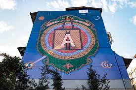 位於大安區永康街永康公園附近的一棟房子牆面上 出現一大片gucci藝術插畫 以深藍色為底搭配精緻的圖騰 這幅畫為英國藝術家alex merry的作品 上面畫有gucci ophidia托特包圖案 大大的 a 字為該名藝術家姓名縮寫 也藉此宣傳gucc fair grounds ferris wheel grounds