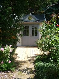 Tiny Clockhouse Gartenhaus In Hellgrau Und Weiss Umgeben Von Romantischen Rosenstrauchern Gartenhaus Gartengebaude Gartenhaus Gmbh