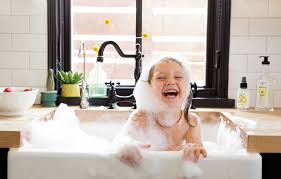 girl in kitchen sink bathtub laughing