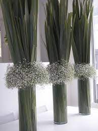 Baby S Breath And Flax Leaves In Glass Vases Bold And Unique Centrepiece For Your Wedding Dinner Set Flower Arrangements Vase Arrangements Floral Arrangements
