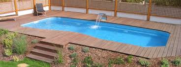 Faucet Made From Silver Colored Metal Pouring Water Into A Blue Pool With Irregular Shape Pale Brown Wooden P Small Backyard Pools Backyard Pool Small Backyard