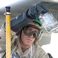 Aviation Warfare System Operator 2nd Class Travis Dasher, assigned to  Patrol Squadron Four Seven (VP-47), surfaces for air as he manually  inflates his flotation vest.