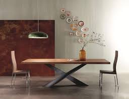 The table's rich stain hue highlights the wood's natural grain, creating a subtle sunburst effect. Uneven Edge Dining Table By Riflessi