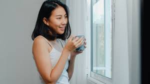 Happy beautiful asian woman smiling and drinking a cup of coffee ...