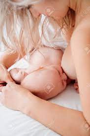 Close Up. Nude Woman Is Lying With A Baby In A White Bed Feeding Breast Milk.  Stock Photo, Picture and Royalty Free Image. Image 161050052.