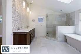 Brushed nickel shower head with digital shower valve, victoria and albert bathtub, curbless shower with hidden shower drain, flat pebble shower floor, shelf over tub with led lighting, gray vanity with drawer fronts, white square. Bathroom Remodel Ideas 5 Innovative Ways To Live In Luxury
