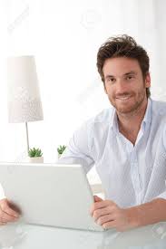 Happy handsome young man sitting and working with computer. Portrait Of Happy Man Sitting At Home With Laptop Computer Smiling At Camera Stock Photo Picture And Royalty Free Image Image 10373312