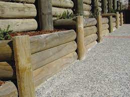 Installation of timber poles for retaining wall. Edged Half Rounds Goldpine