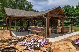 This Outdoor Entertaining Space Features An Open Pavilion With Tv Kitchen And Fireplace The Nearby Poo Backyard Pavilion Outdoor Entertaining Spaces Backyard