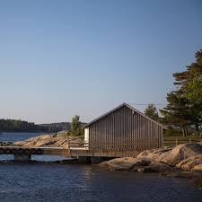 A large luxurious house boat with a covered deck at the top and a large seating area on either side of the boat. Boathouse Architecture Dezeen