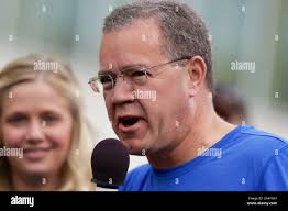 Berkshire Hathaway investment manager Ted Weschler speaks as and Tracy Britt  Cool, Chairman of Berkshire companies Benjamin Moore, Johns Manville,  Oriental Trading Company and Larson-Juhl, looks on, left, before a 5K run