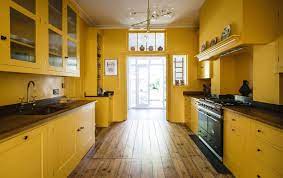 Midcentury yellow kitchen cabinets and appliances. The Life Affirming Joy Of A Brilliantly Bold Yellow Kitchen As You Walk Into The Room You Can T Help But Smile Country Life