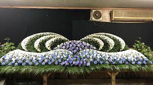 If you replaced them with two full sized peacock feathers and orchid stems instead of leaves on the bottom tier, this would be pretty much. The Art Of Japanese Funeral Floral Arrangements Colossal