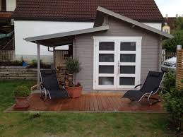 Pultdach Gartenhaus In Hellgrau Und Weiss Auf Der Naturholzterrasse Kann Man Sich Gemutlich Im Liegestuhl Sonnen Gartenhaus Grau Gartenhaus Pultdach Gartenhaus