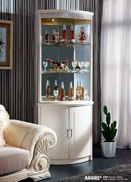 We love the white and antique brass color combination and the contrast is stunning. Inspiration For Corner Wine Rack In The Dining Room The Bottom Would Remain Open And Have A Simple Wine Ra Corner Wine Cabinet Wine Cabinets Wine Bar Cabinet
