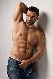 Fashion Model. Portrait Of Handsome Sexy Young Man Standing By The Wall.  Closeup Of Hot Muscular Male Body With Pure Skin And Pumped Muscles. Health  Concept. High Resolution Stock Photo, Picture And