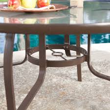 This round patio dining table offers room to seat six. 48 Inch Round Glass Top Outdoor Patio Dining Table With Umbrella Hole The Outdoor Nest